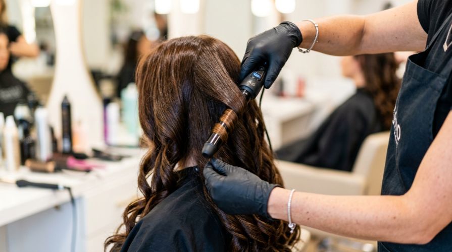 Welcoming interior of Incredible Hair Beauty salon in Liverpool NSW, with a stylist giving a client a professional blow-dry.