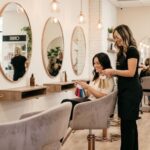Hair and beauty salon consultation with client reviewing colour swatches